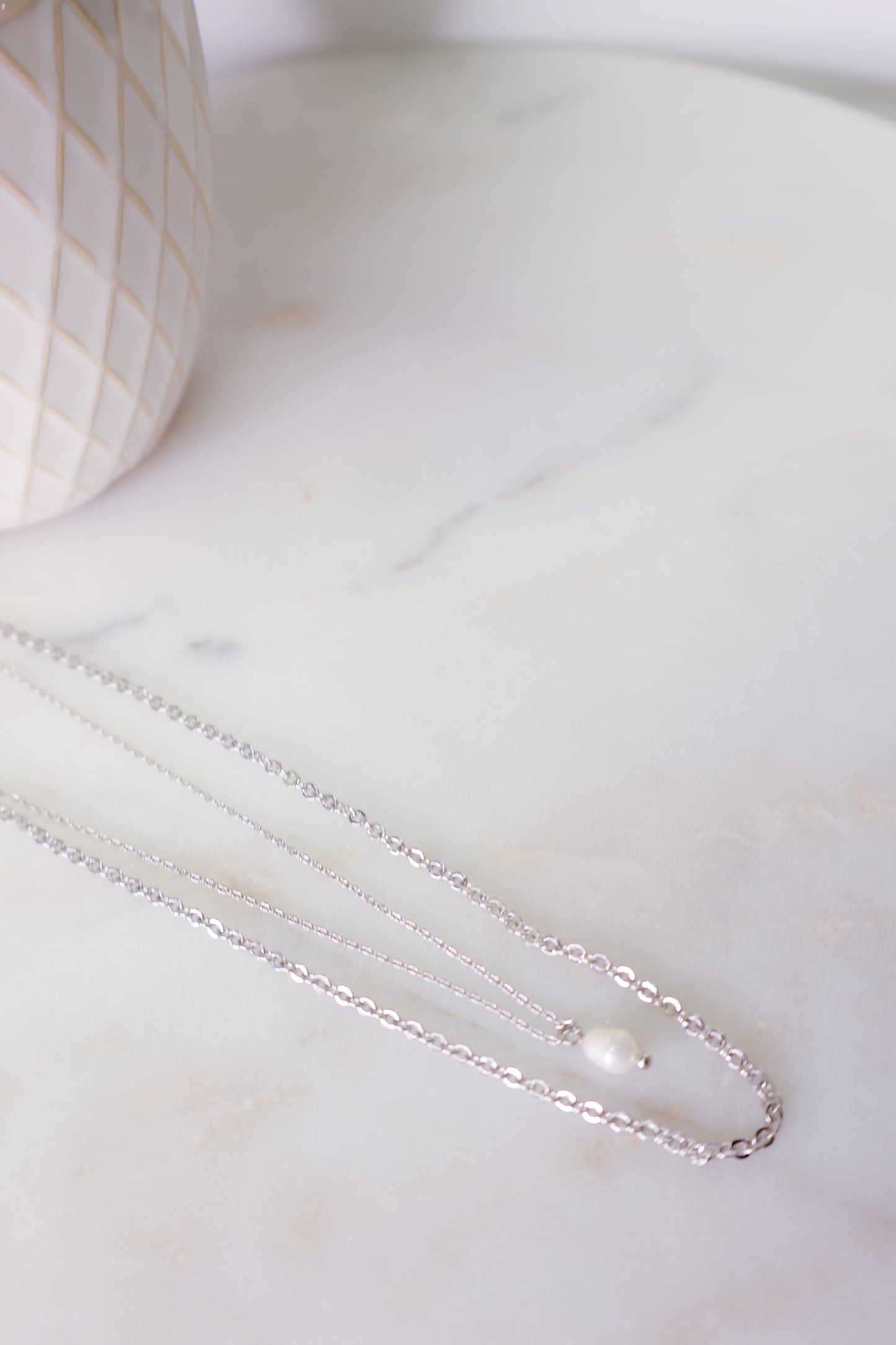 Closer look of the Floating Pearl Necklace on flat surface