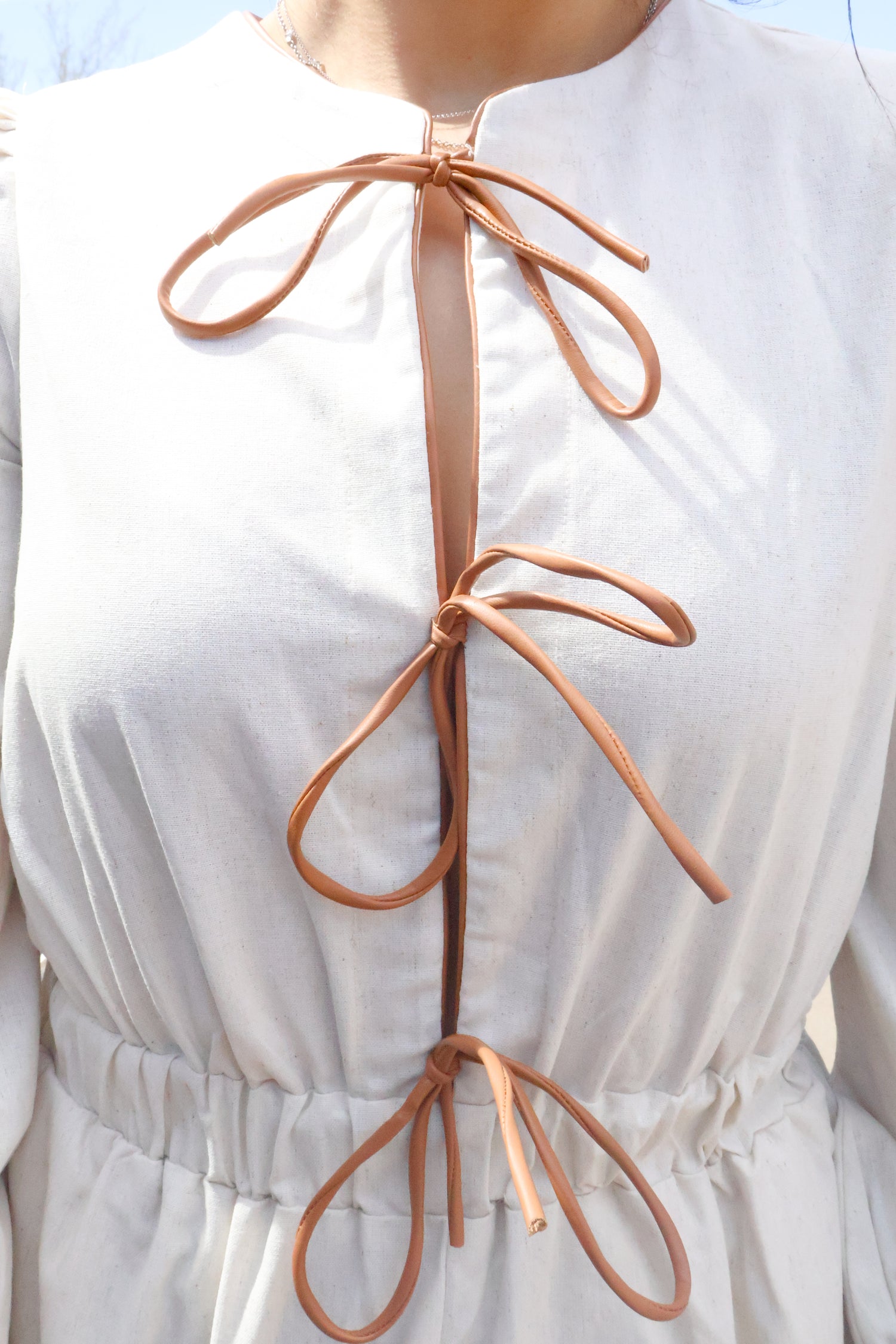 VEGAN LEATHER LACE-UP ROMPER – LONG SLEEVE, ELASTIC WAIST, BOHO CHIC OUTFIT BOW CLOSE UP