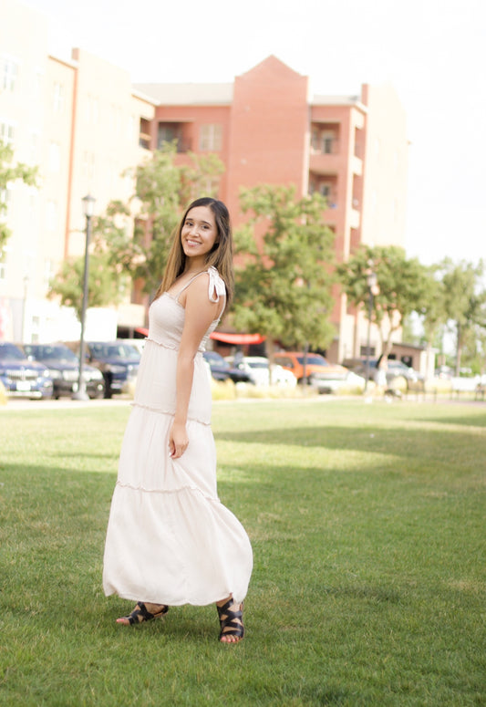 The sweet cream color is such a staple for the new season. It also features a maxi length, smocked bodice, and tiered layers. 